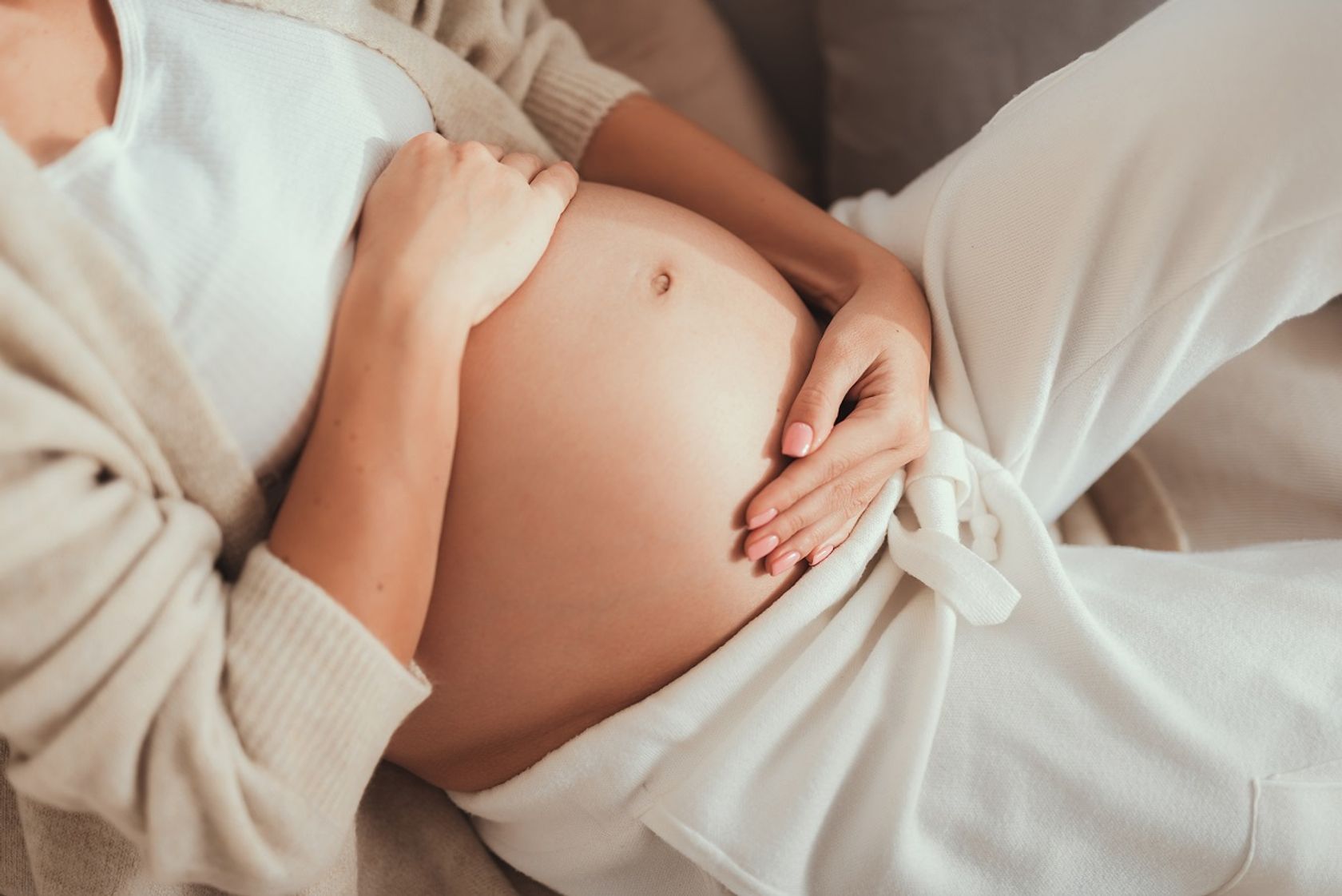 Schwangere hält sich Bauch mit Ungeborenem