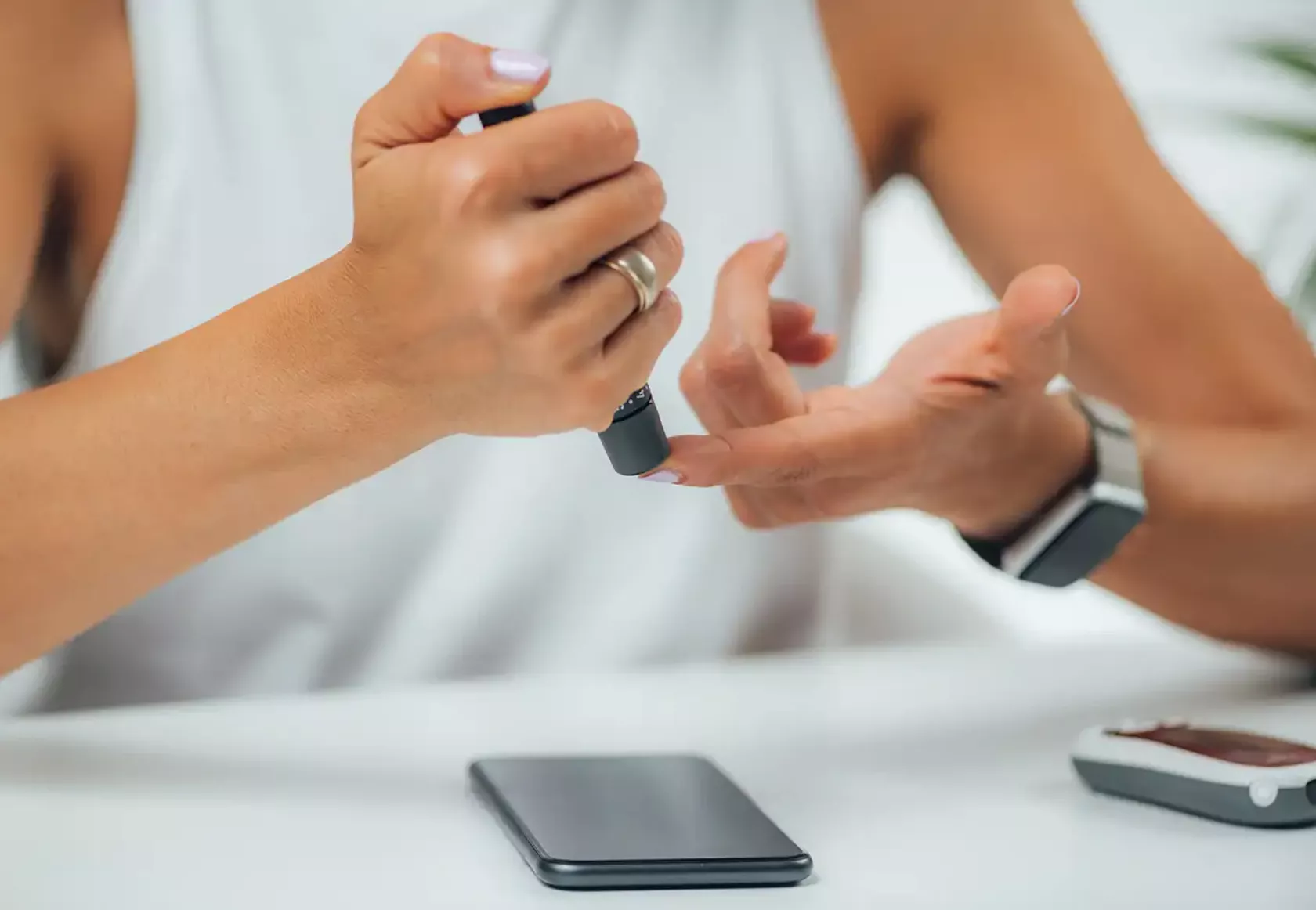 Diabetikerin checkt ihren Blutzucker, Smartpen und Smartphone bei ihr.