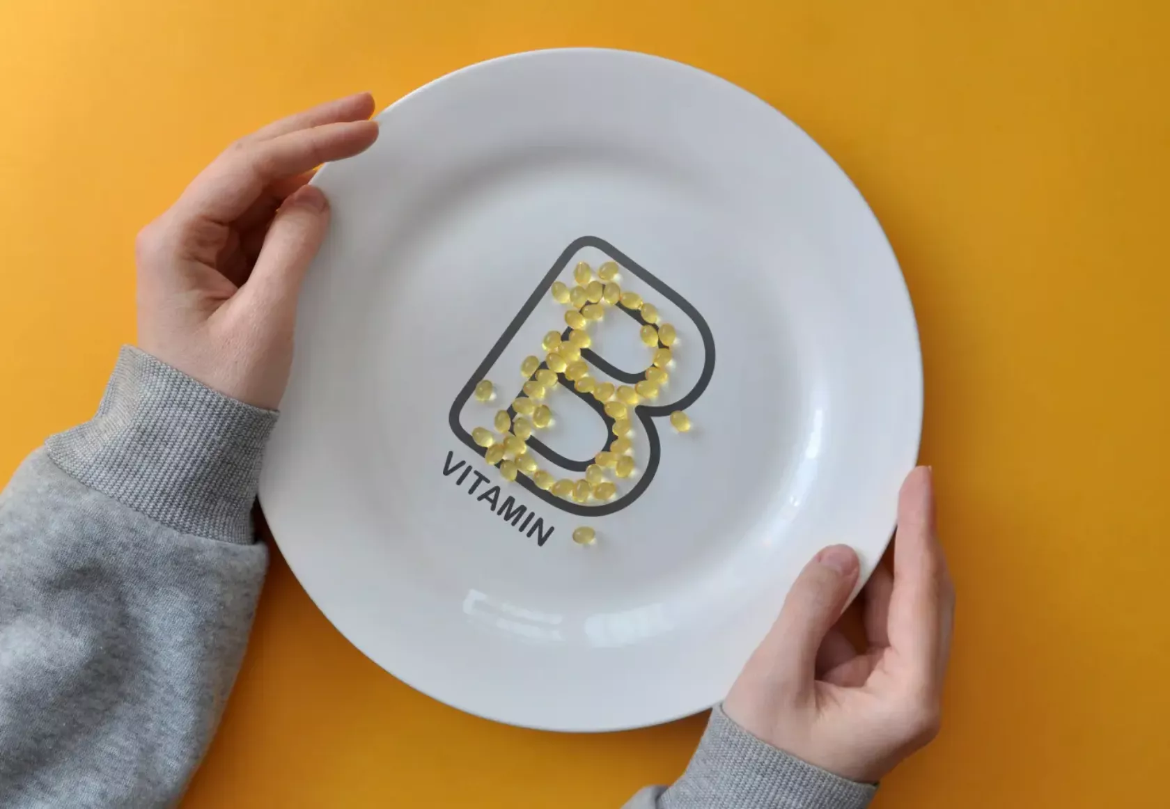 Mit Vitamintabletten ist der Buchstabe B auf einem Teller gelegt und verwackelt - Symbol für Vitamin-B-Mangel.