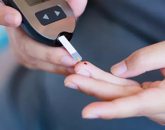 Blutglukose-Test bei Diabetes, Blutstropfen auf dem Finger und Testgerät mit Teststreifen