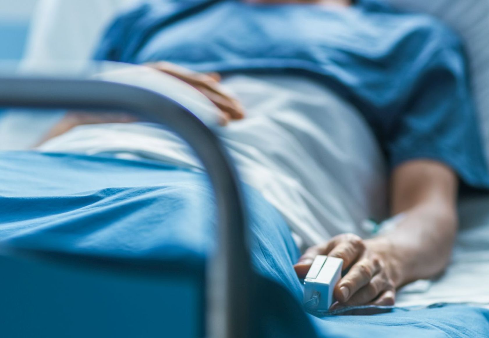Ein kranker Mann liegt in einem Krankenhausbett.
