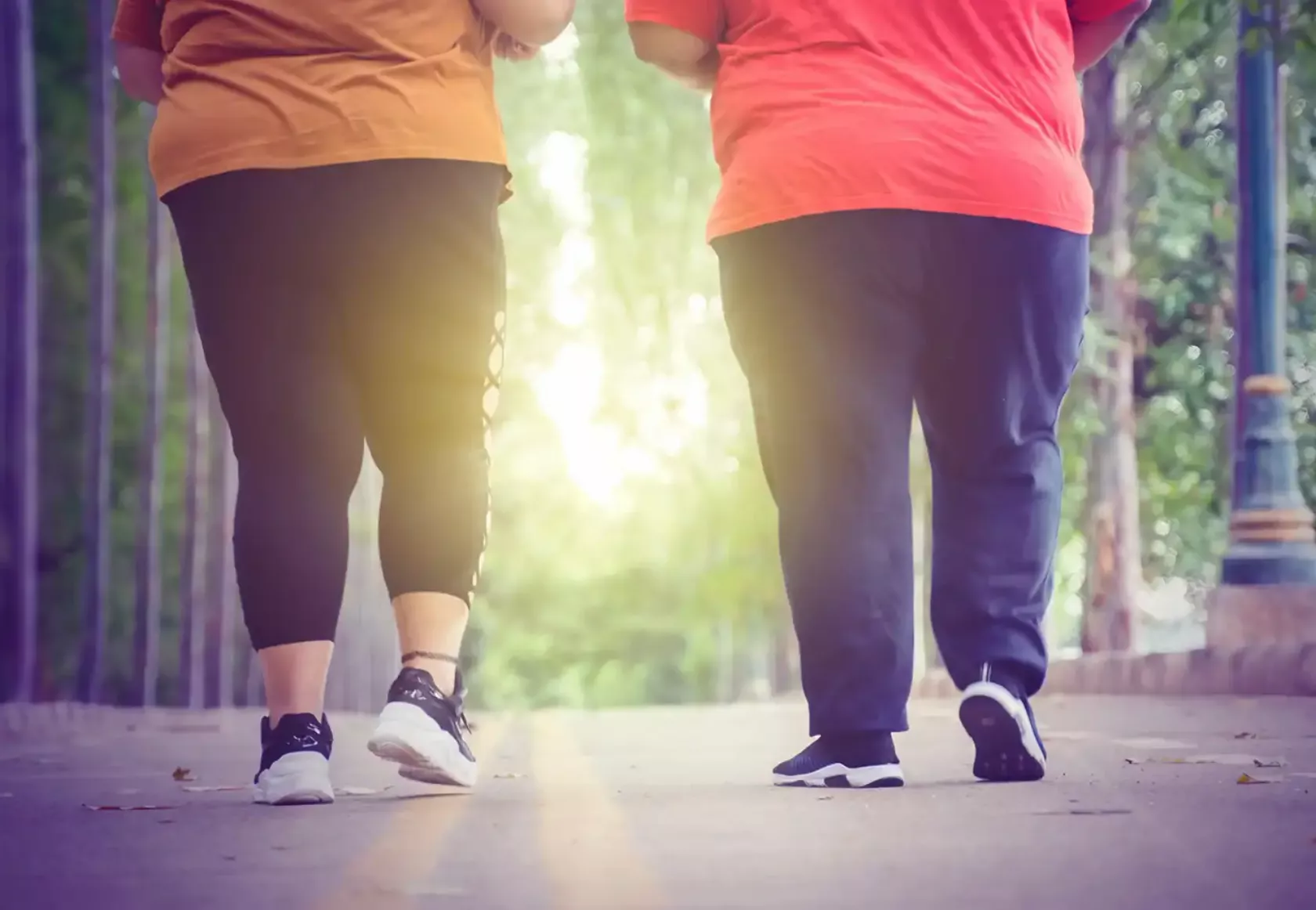 Adipöse Frau und übergewichtiger Mann laufen zu Trainingszwecken zur Gewichtsreduktion.