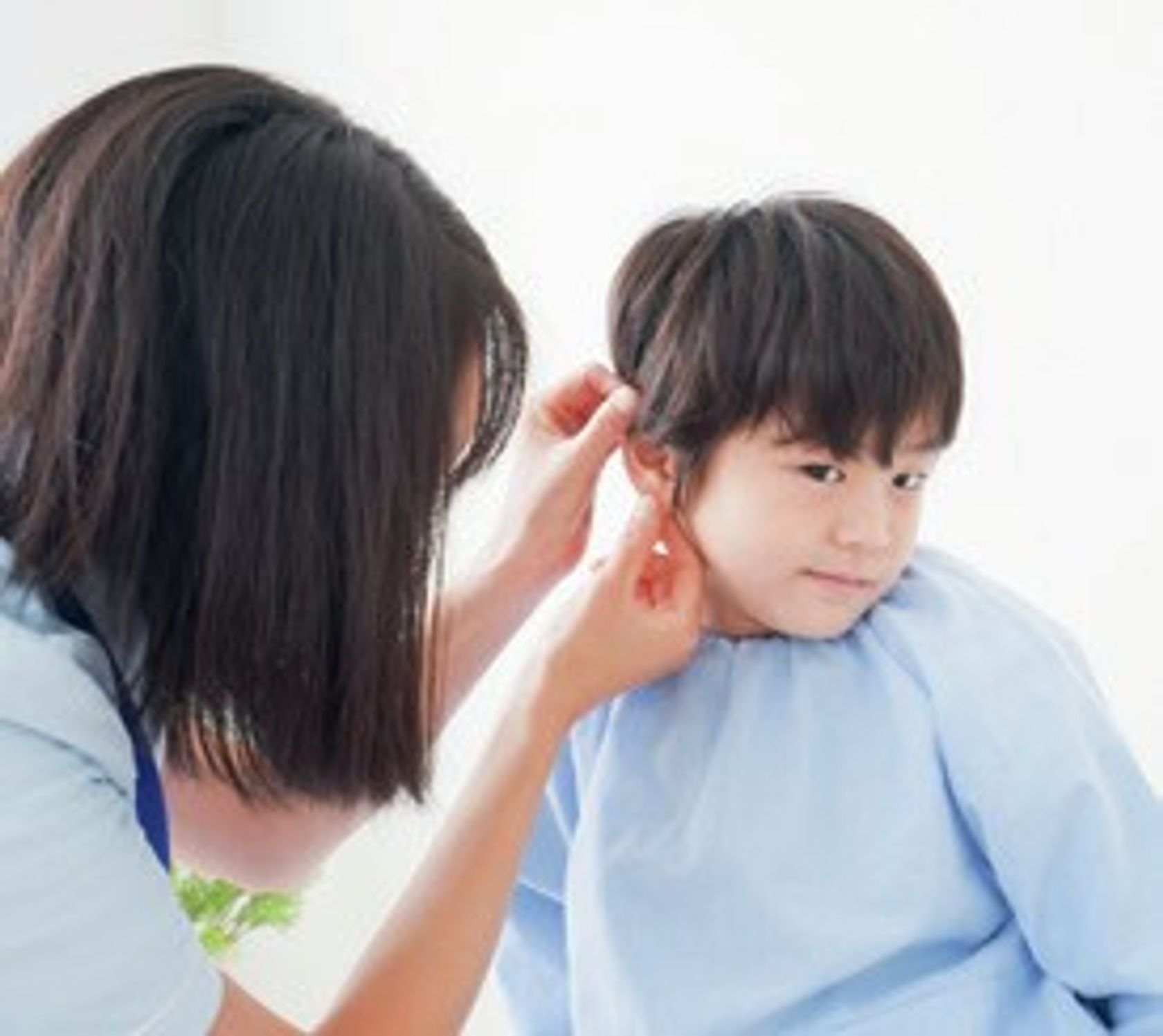 Ärztin untersucht Jungen am Ohr