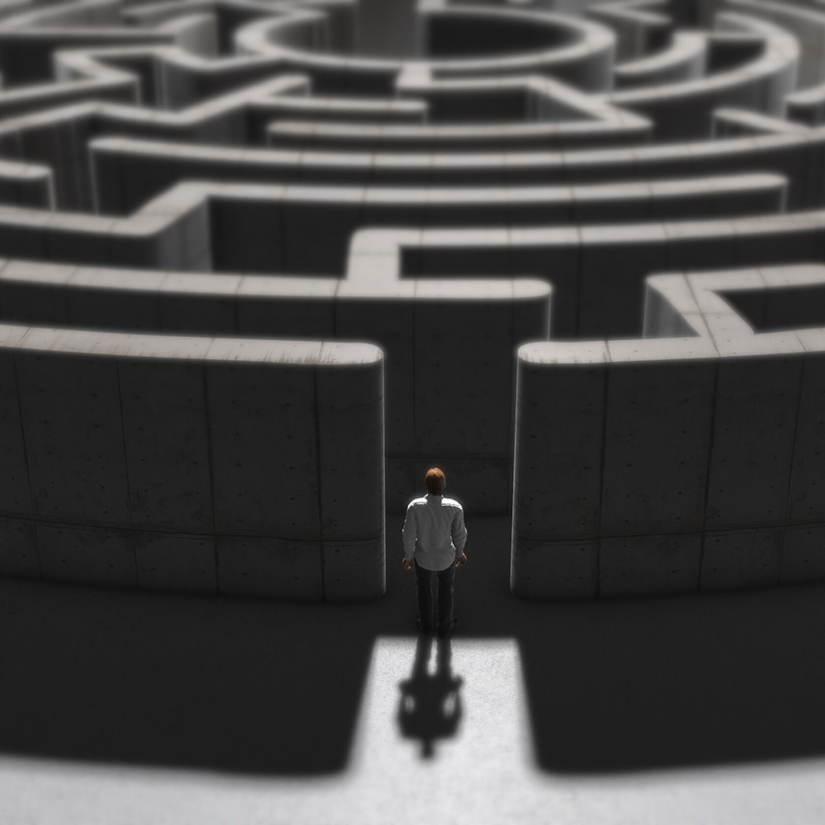 kleiner Mensch steht am Eingang eines großen Labyrinths oder Irrgartens