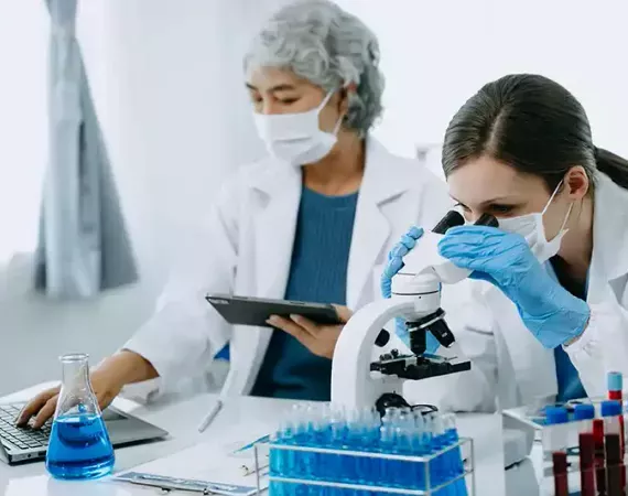 Zwei Wissenschaftlerinnen arbeiten im Labor zusammen an der Auswertung von Blutproben.