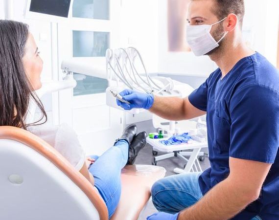 Frau lässt vom Zahnarzt ihre Zähne kontrollieren.
